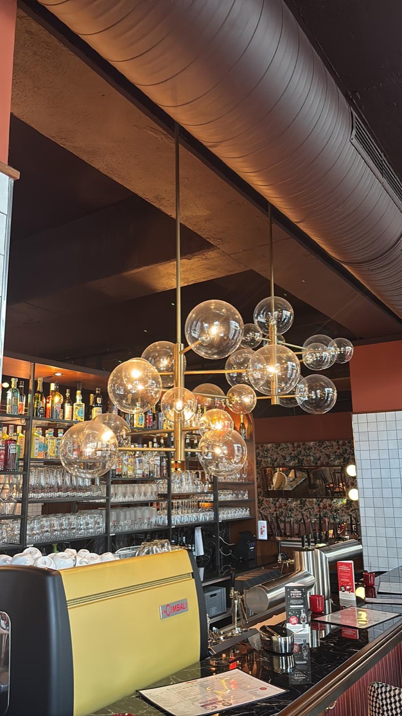 Design-Pendelleuchten über einer Bartheke in einem Gastronomiebetrieb